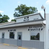 AIM Water service center building with signage for Kinetico Non-Electric water softeners.