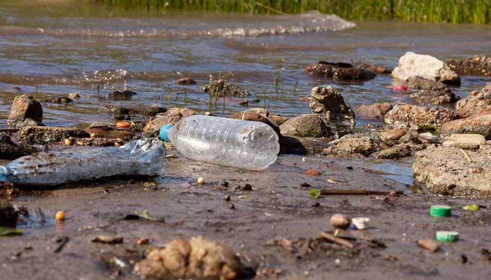 Beach heavily littered with plastic debris. Shows plastic pollution and need for marine management.