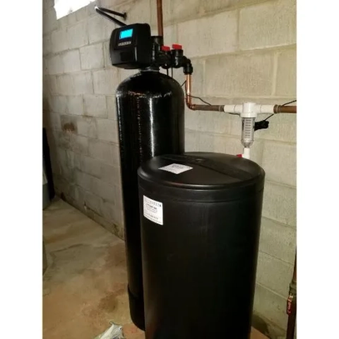 Residential water softener system installed by All Safewater Technologies against a concrete wall.