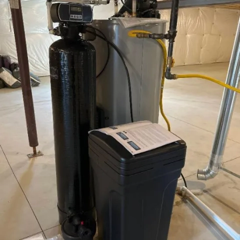 Apollo Home Water Softener: Installed residential hard water treatment system with black resin tank and digital control.