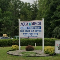 Aqua Mech water treatment sign promoting sales, service, and essential salt supplies for residential systems.