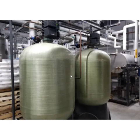 Industrial water softener tanks with top-mounted control valves by CE Water Management.