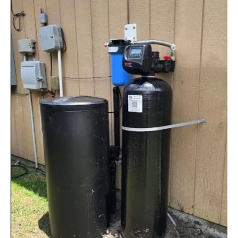 Outdoor water softener tank installation by Custom Filtration Plumbing service company