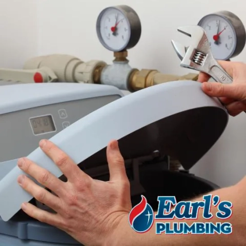 Professional plumber from Earl’s Plumbing fixing a home water softener unit in Frisco, Texas