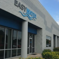 Close-up of the EasyWater logo above the front door, featuring a stylized blue wave.