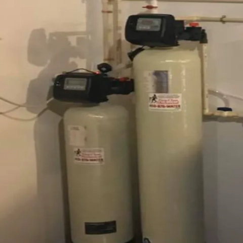 Professional twin-cylinder household water softening loop installed in a utility space by First Class Mechanical