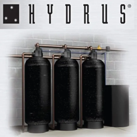 HYDRUS Series Commercial Water Softener system with three large black tanks and copper piping.