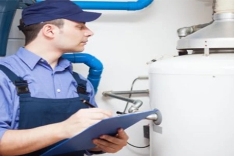 Hague Water Conditioning technician checking a water heater during a service appointment.
