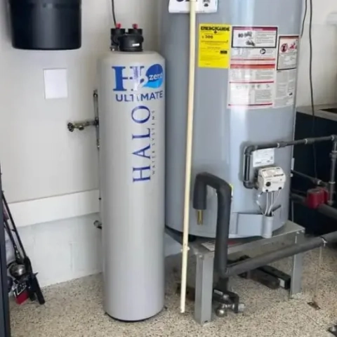 Halo H2 ZERO ULTIMATE Water Softener next to a traditional hot water tank installation in a garage.