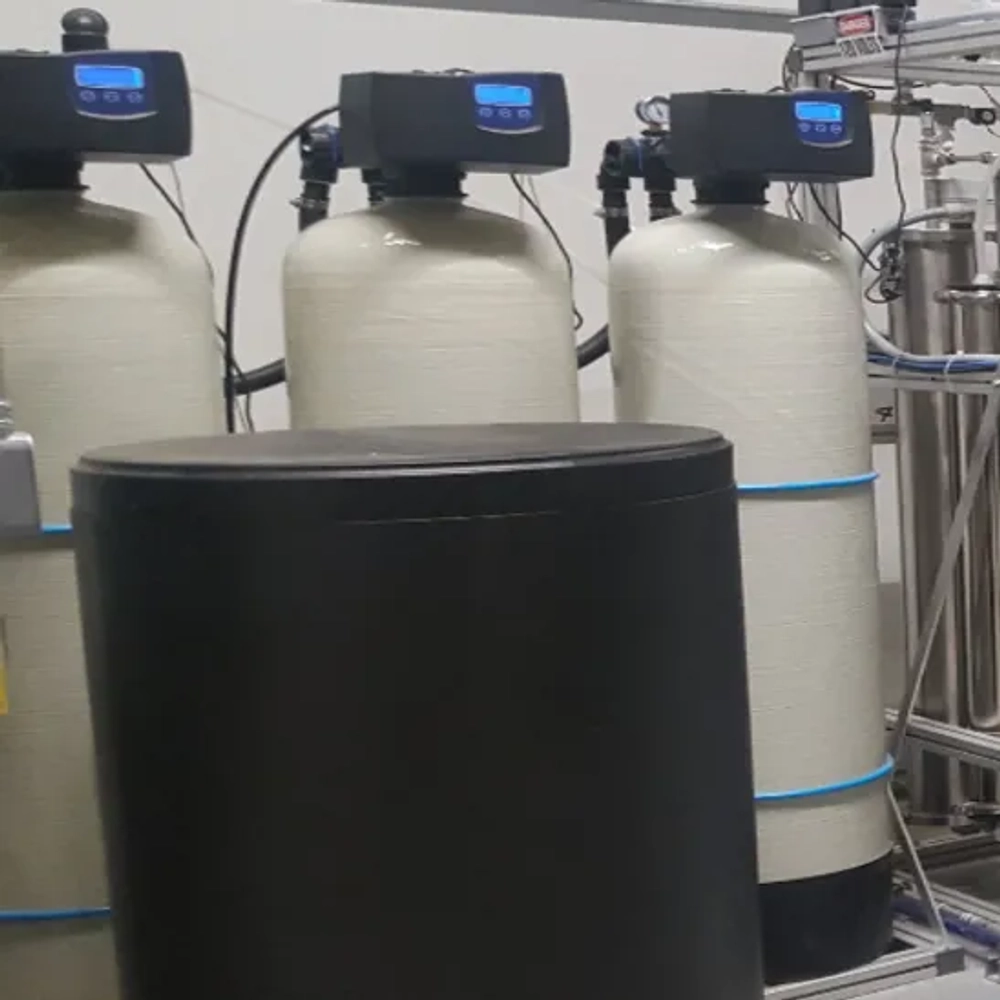 Professional multi-tank continuous-flow industrial water softening skid calibrated to treat bulk process water volumes and neutralize scaling minerals, manufactured by HydroMax Inc