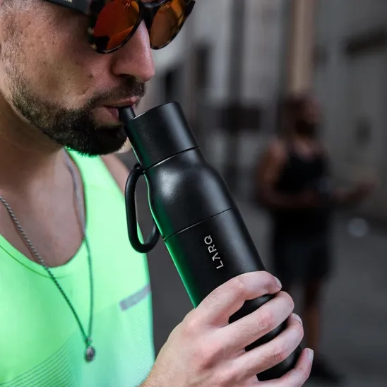 A man drinking water from LARQ Insulated Filtering Water Bottle in gym.