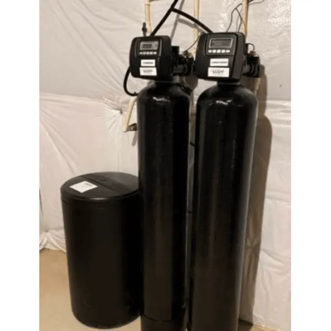 Martins Water Treatment water softener.png showing a premium twin-alternating tank water softening system with dual almond fiberglass cylinders and an adjacent black brine salt reservoir