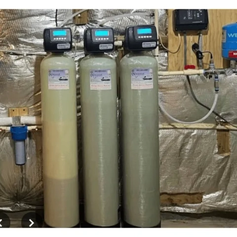 Professional whole-property ion-exchange water conditioning system expertly installed in a basement utility area by National Water Service