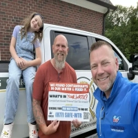 Happy customer with North Carolina Water Company technician and truck in Charlotte