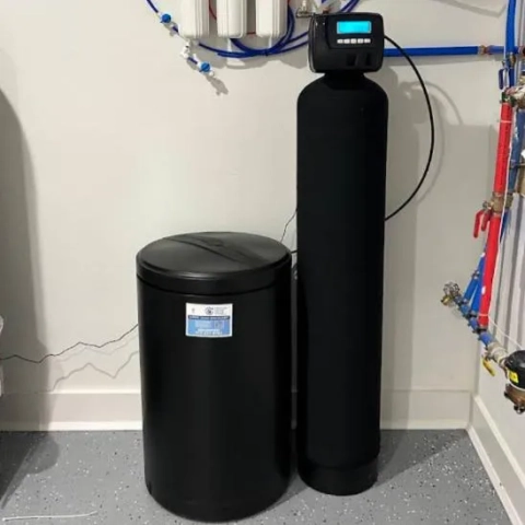 Prestige Water Group installed black residential water softener system with brine tank and digital control head.