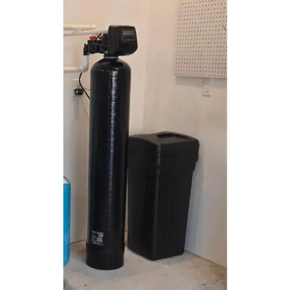 Pure Water Plumbing black water softener and brine tank setup installed against a white wall and pegboard.