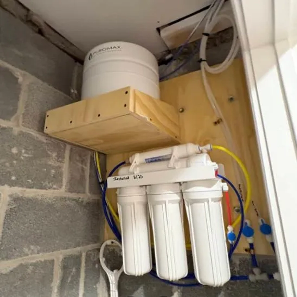 Installed Puromax PC 5-stage RO system with holding tank, providing filtered drinking water for home.