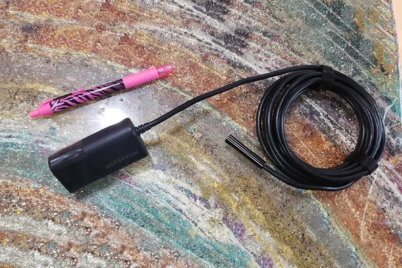 DEPSTECH Wireless Endoscope Camera with a pen-sized Wi-Fi Device and flexible stiff cord.