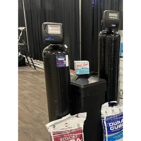 Sunrise Springs Water Softener units displayed with bags of salt and water testing products.