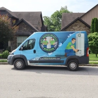 Side view of The Hot Water Heater Pros service van with water heater graphic and contact phone number.