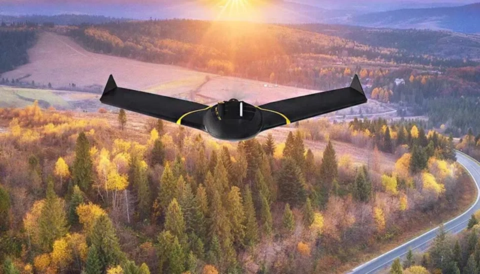 Photograph of the SenseFly eBee X fixed-wing drone. The drone is predominantly white with a slender fuselage and large, elongated wings, characteristic of a fixed-wing design. A propeller is visible at the rear. The image highlights the drone's aerodynamic shape and size intended for long-duration flights and wide-area surveying, as discussed in the article about drones in water resources management.