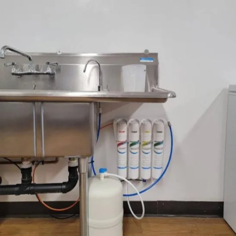 RO water system by The Softener Guy, with visible storage tank and filter array next to a utility sink.