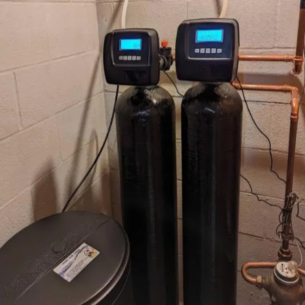 The Softener Guy LLC twin-tank water softener installation with digital control heads and brine tank in a basement.