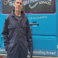 A professional plumber and the side of a van with Three Way Plumbing Services branding