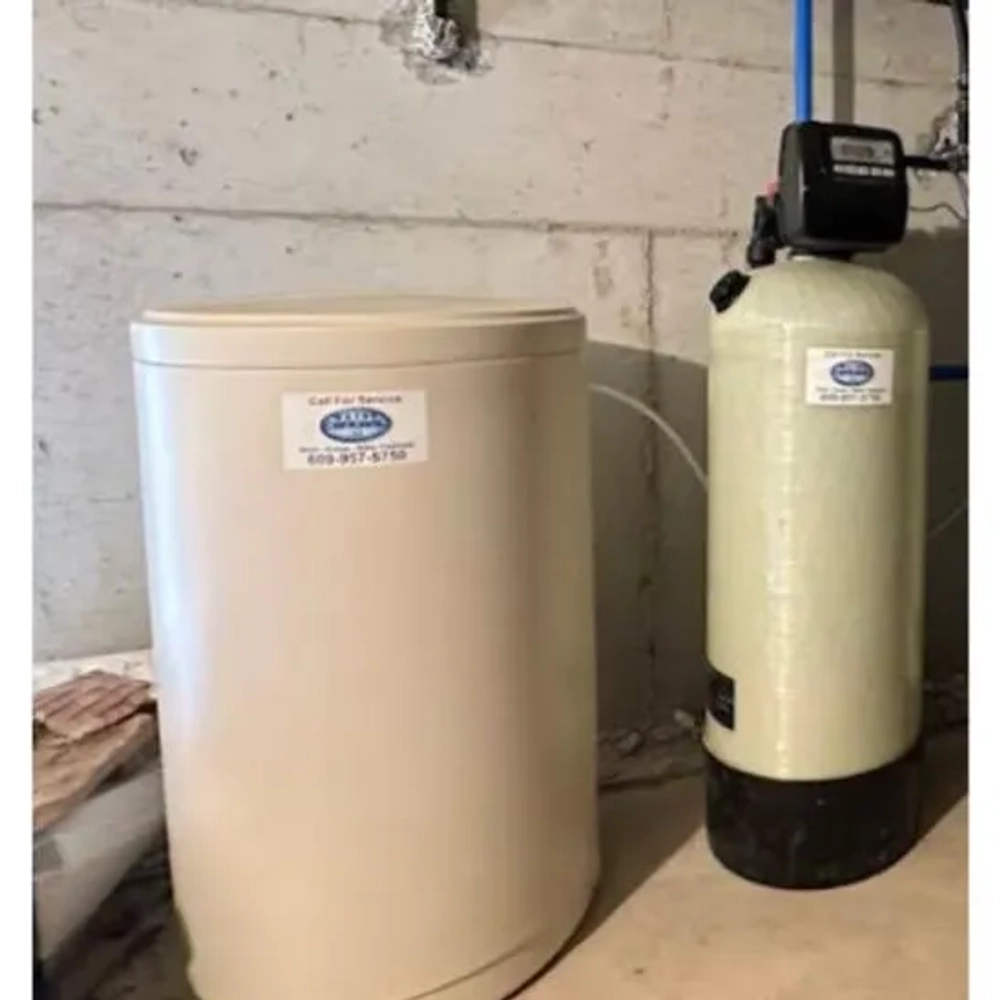 Water Central water softener and large brine tank installation for complete house water conditioning.