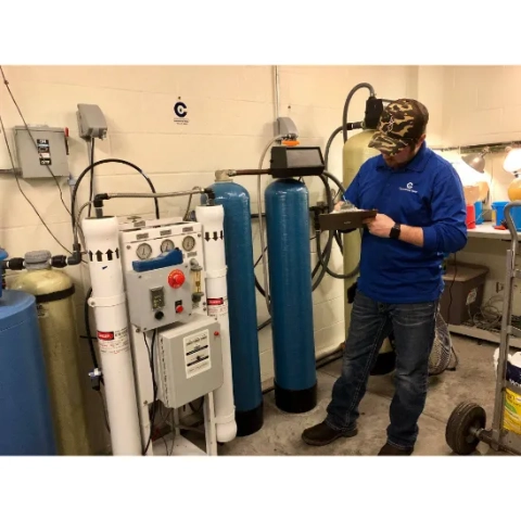 Commercial Water technician inspecting an industrial reverse osmosis and water softener system.