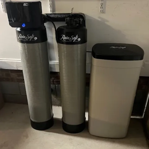 RainSoft EC5 water softening system with dual filtration tanks and brine storage tank in a garage.