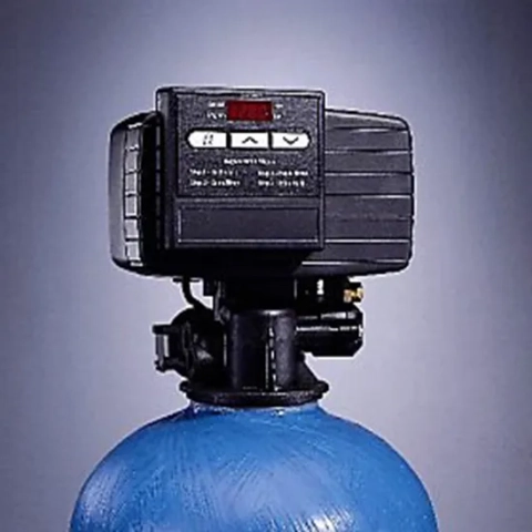 Digital control valve on a blue FC30WM water softener tank featuring automated programming buttons.