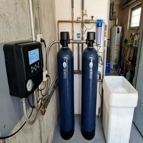 Modern twin-tank water softener featuring an electronic control valve in a home installation.