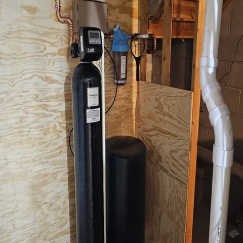 a) Whole-house water softener system installed by SISU Plumbing LLC. with copper and PVC piping.