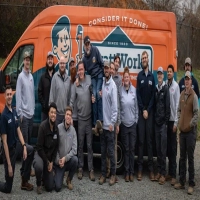A group photo of the WyattWorks Plumbing and Heating team with their branded service van.