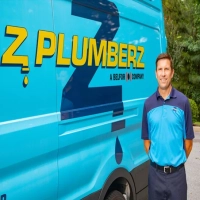 Z Plumberz of Greater Milwaukee technician standing by a blue service van offering local plumbing services.