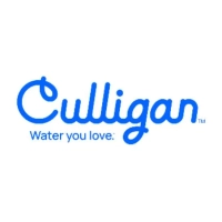 Culligan Water team members posing together indoors in front of wall awards and diplomas.
