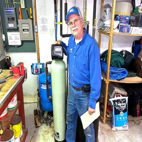Reynolds Purified Water technician in Indianapolis servicing a residential water softener system.