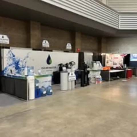 Clear Water Systems trade show booth displaying water softeners, filters, and coolers at a convention.